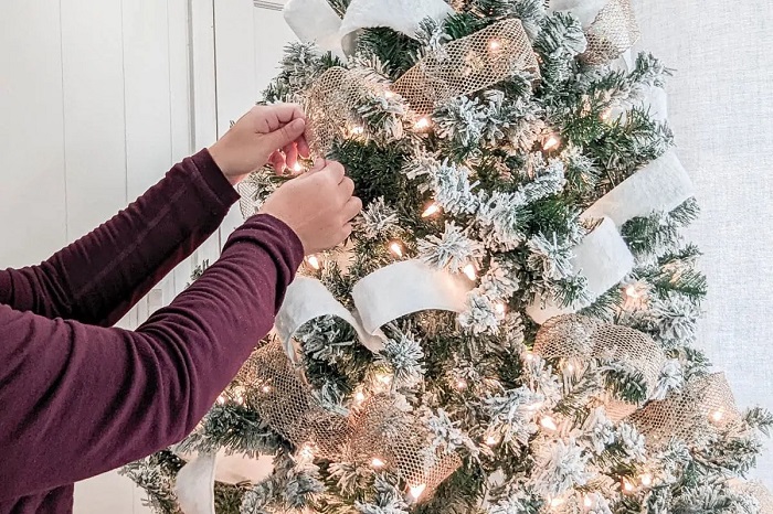 Add ribbon or a garland to decorate a Christmas tree. Image via Pinterest.
