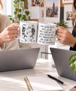 Personalized funny bestie mug with two dancing skeleton figures labeled "Amelia" and "Olivia" on the front, and a cheeky, profanity-laced soul sister friendship quote about staying ghost besties on the back