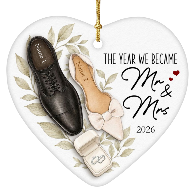 The Year We Became Mr & Mrs personalized wedding ornament in a heart-shaped ceramic design featuring a groom's dress shoe and bride's wedding shoe with a ring box, wedding year 2026 shown beneath the quote